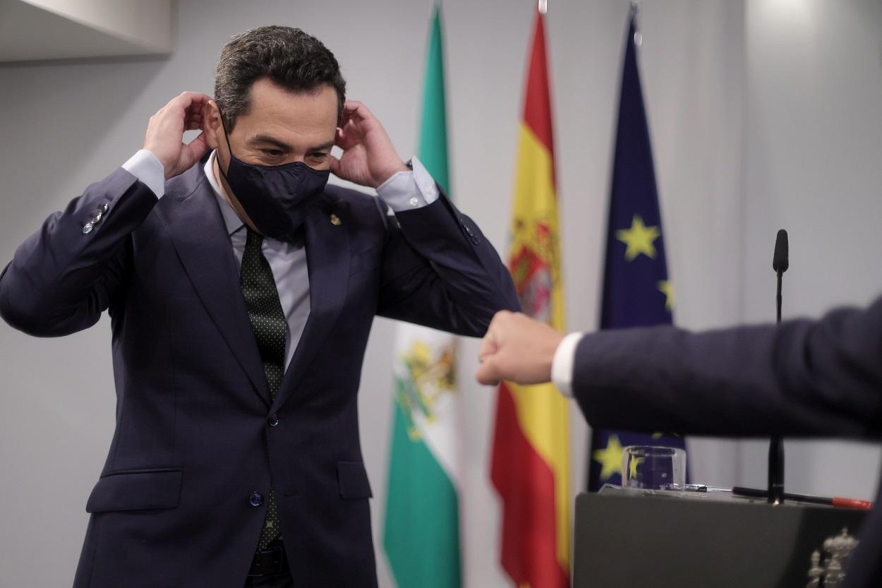 El presidente de la Junta de Andalucía, Juan Manuel Moreno Bonilla, se pone la mascarilla tras ofrecer una rueda de prensa. Fuente: Europa Press.