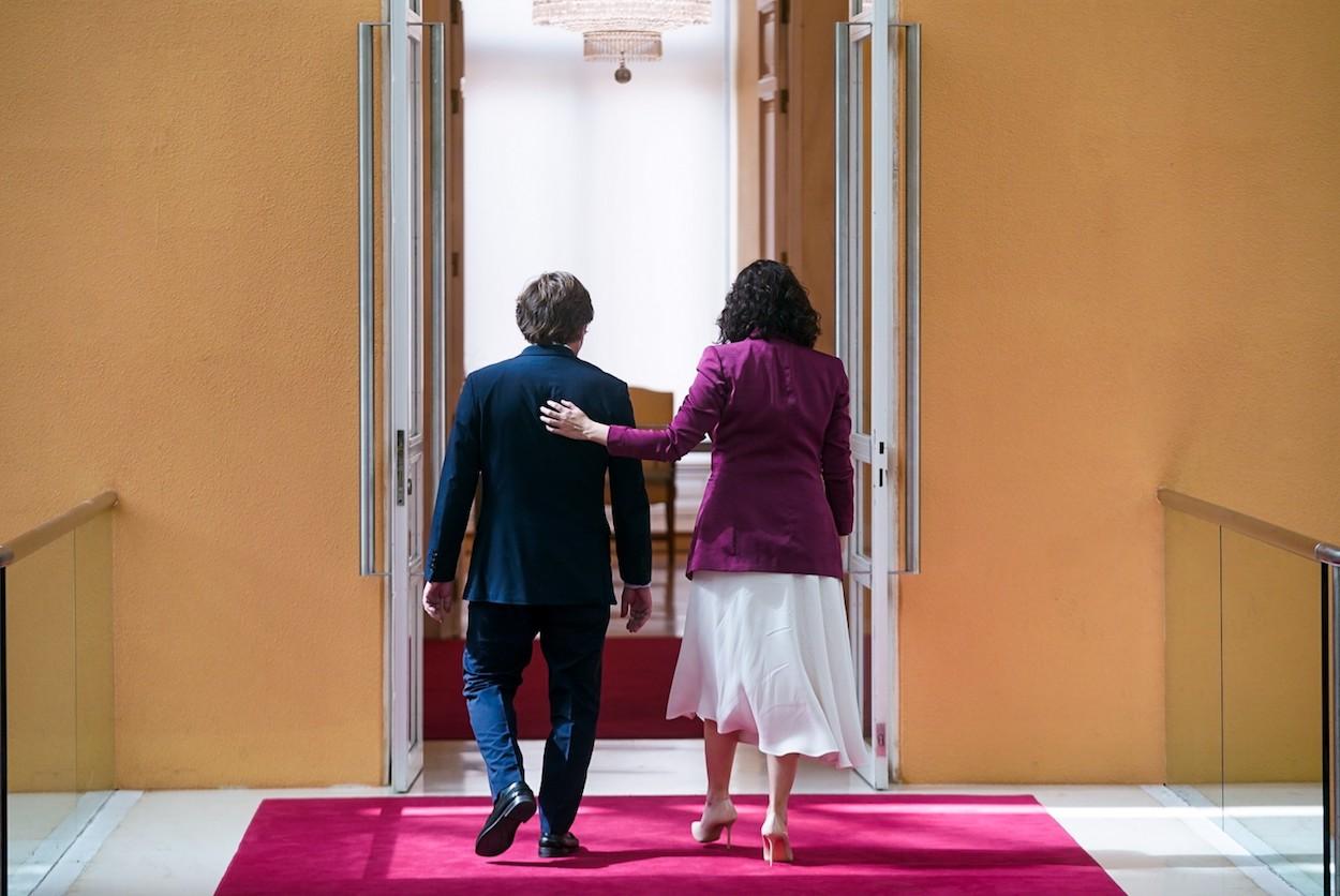 La presidenta de la Comunidad de Madrid, Isabel Díaz Ayuso, y el alcalde de Madrid, José Luis Martínez Almeida, caminan para realizar la primera reunión institucional tras su toma de posesión, en la Real Casa de Correos