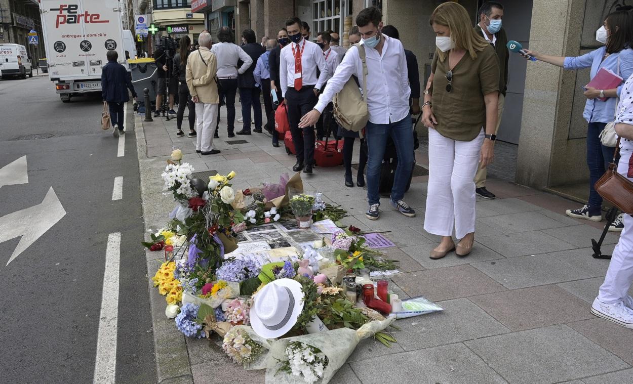 Varias personas observan las flores dejadas en el lugar que fue asesinado Samuel. EP