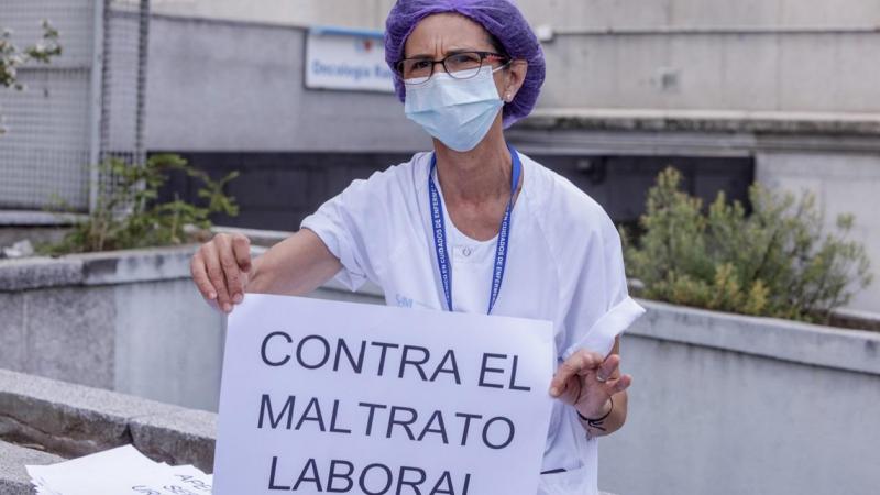 Una sanitaria del Hospital Clínico de San Carlos con un cartel contra la precariedad laboral. EP