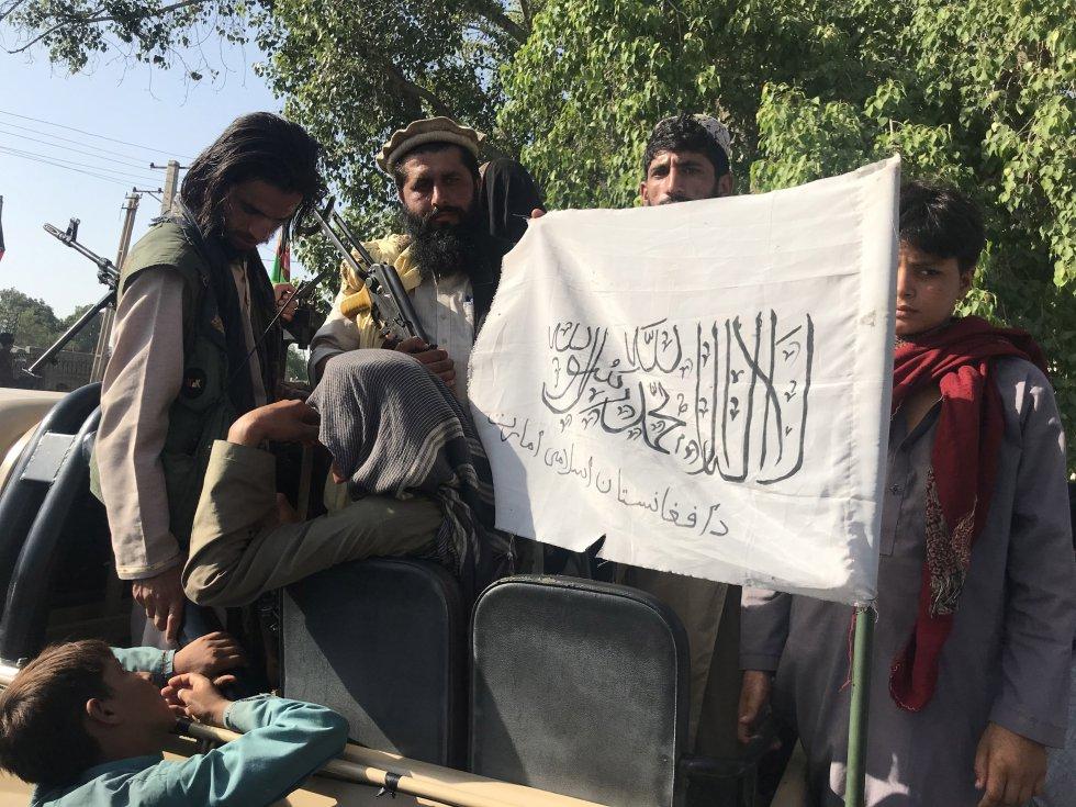 Militares talibanes muestran su bandera tras alzarse con el control de una ciudad afgana. 
