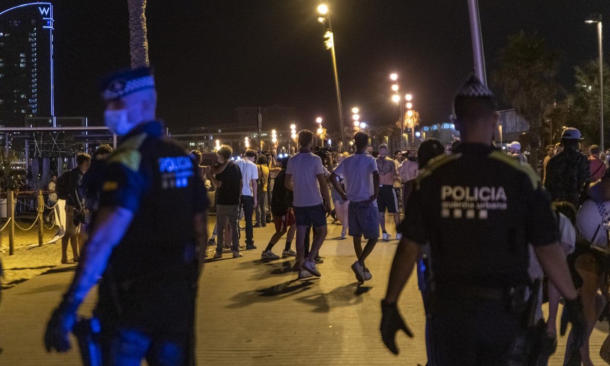 Varios agentes de la Guardia Urbana desalojan a jóvenes de la playa de la Barceloneta. Europa Press