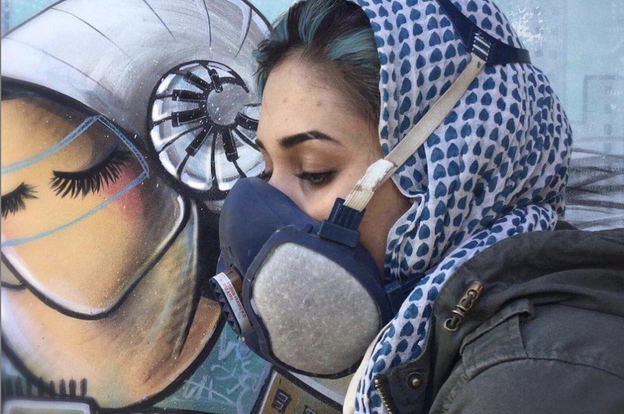 La artista grafitera frente a una de sus obras. Instagram Shamsia Hassani