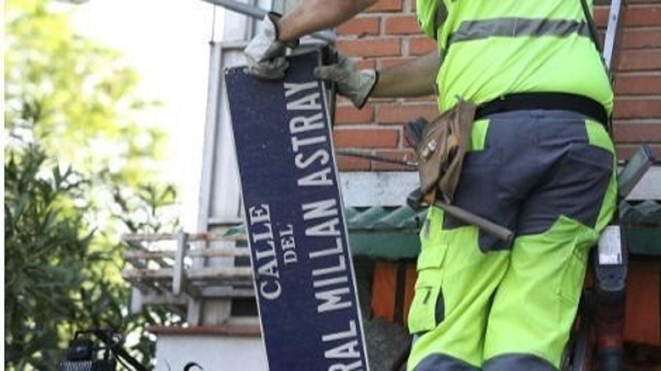 Un operario pone la placa de la calle del General Millán Astray. EP.