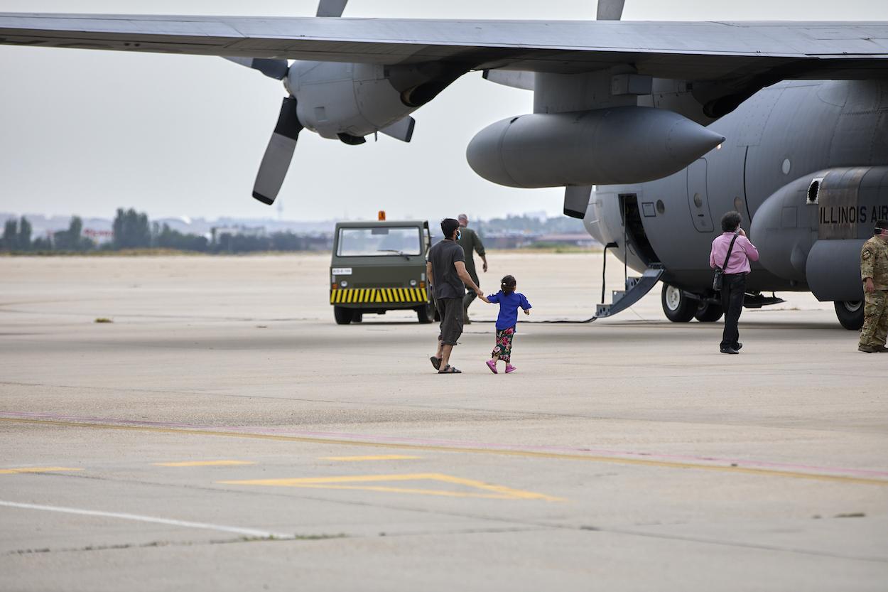 Un niño y un familiar, se dirigen a subir a un avión estadounidense para ser trasladados a Alemania