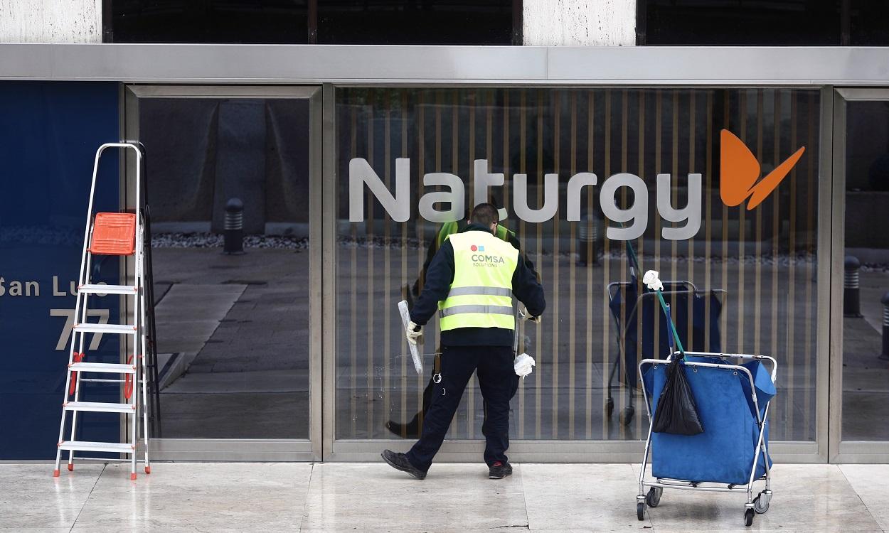 Un operario limpia la cristalera de la sede de Naturgy ubicada en la capital, Madrid. EP