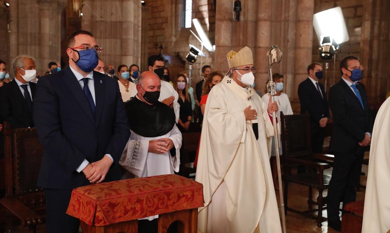 El arzobispo de Oviedo, Jesús Sanz Montes, pasa al lado del presidente del Principado, Adrián Barbón. EP