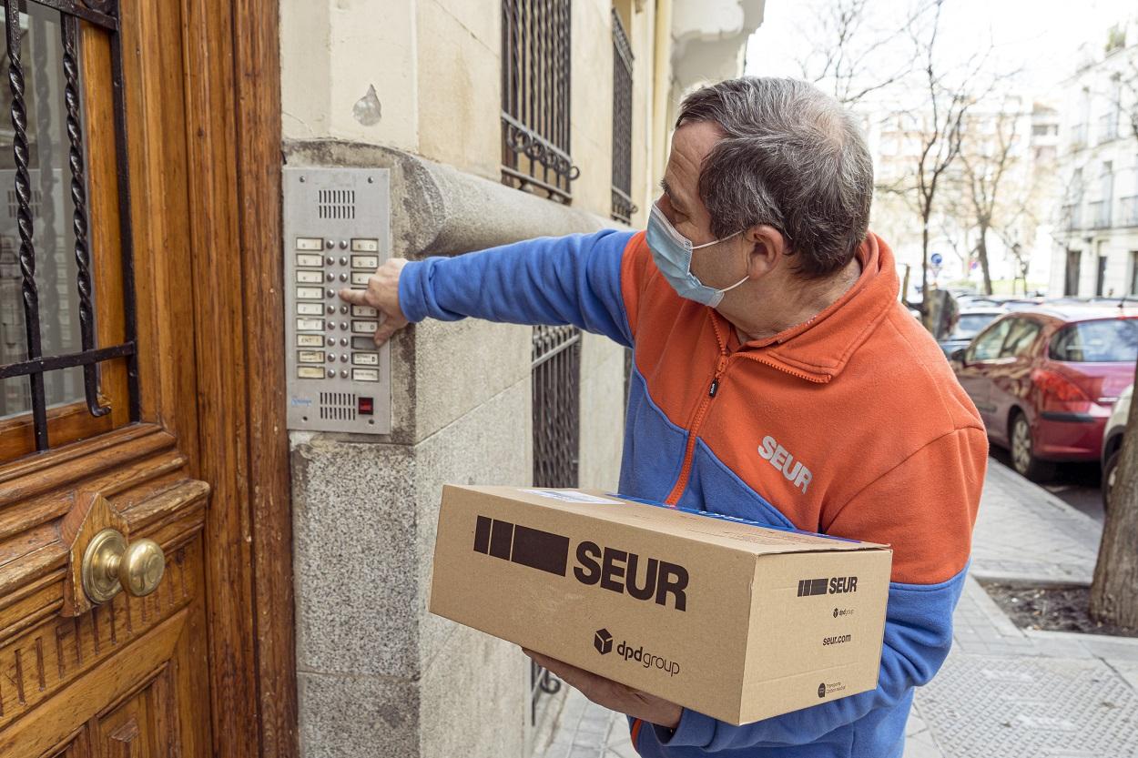 Un trabajador de Seur realiza una entrega