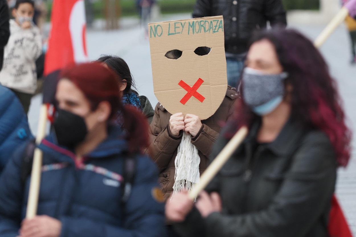 Una persona sostiene una careta donde se lee No Ley Mordaza durante una manifestación contra el encarcelamiento del rapero y poeta Pablo Hasel