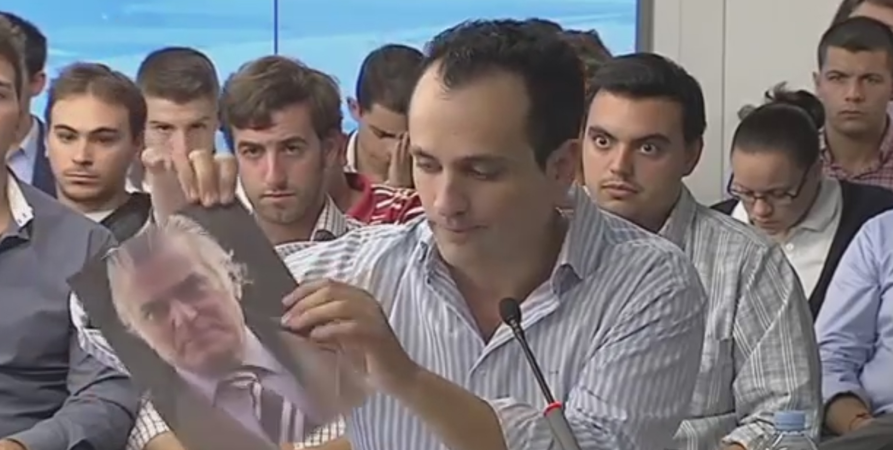 Antonio José Mesa rompe una foto de Luis Bárcenas durante el debate para liderar Nuevas Generaciones de Madrid.