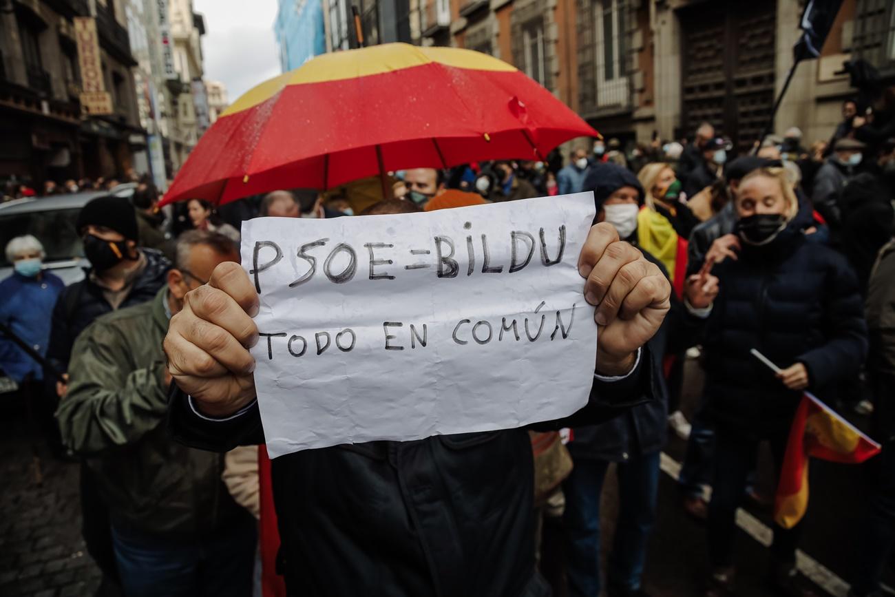Participantes en la manifestación contra la derogación de la Ley Mordaza exhiben un cartel sobre PSOE y BIldu