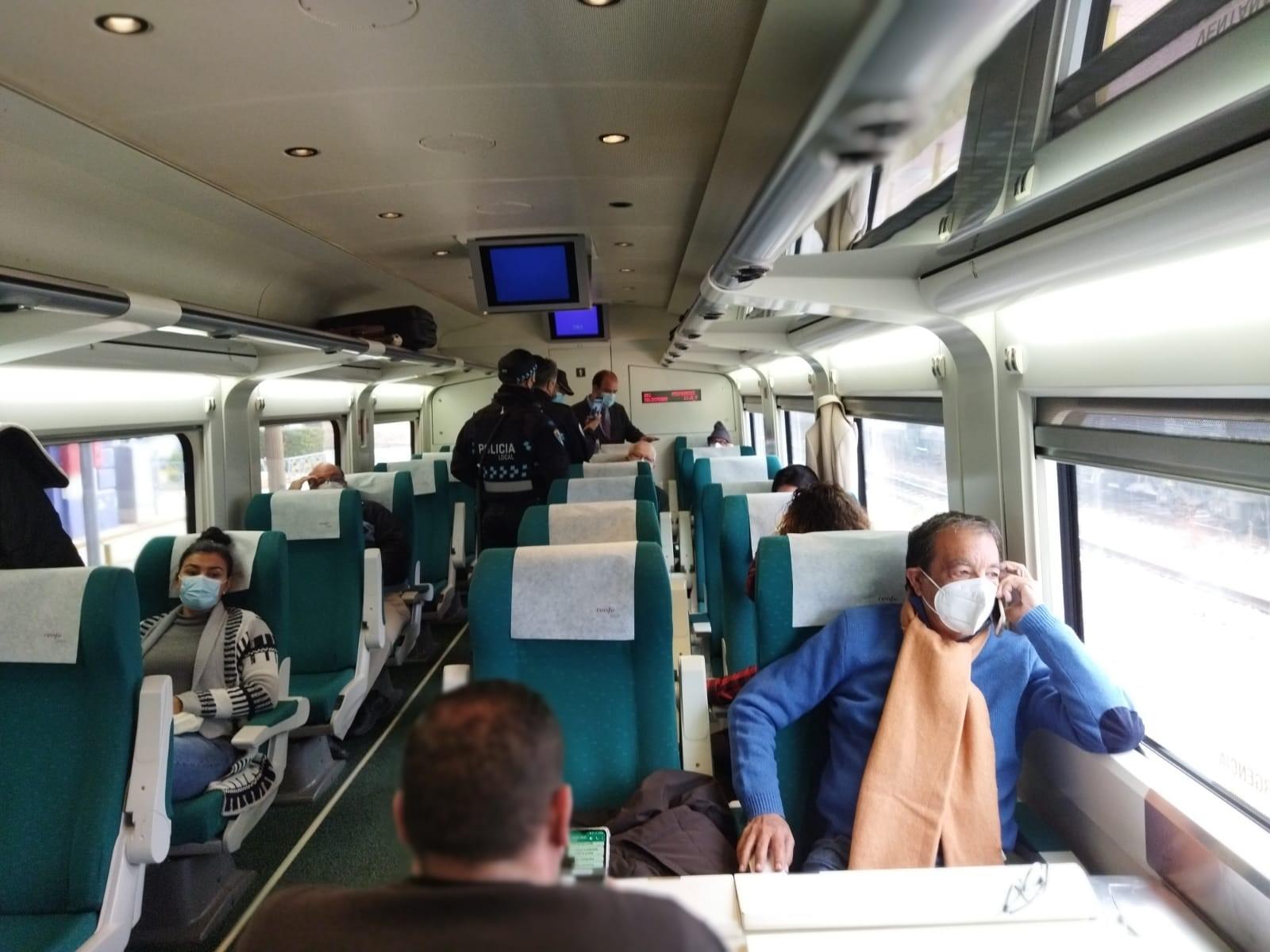 Tres agentes de la Policía intentan convencer a la viajera de ponerse la mascarilla.