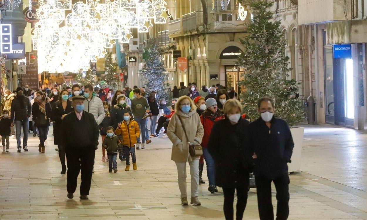 Gente paseando con mascarilla bajo las luces de Navidad de Vigo. EP