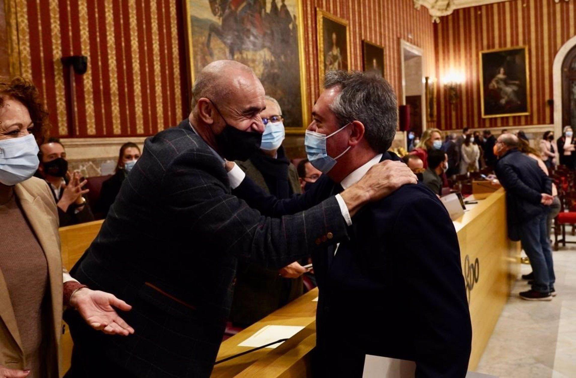 El todavía alcalde Juan Espadas saluda a Antonio Muñoz minutos antes de leer su renuncia al cargo en el Pleno extraordinario del Ayuntamiento de Sevilla.   EDUARDO BRIONES:EP
