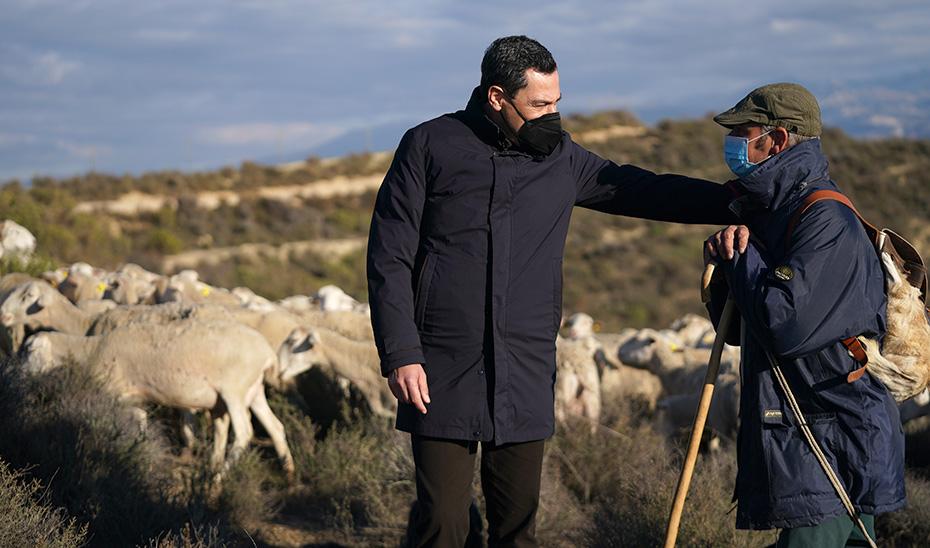 Juan Manuel Moreno Bonilla conversa con un ganadero en Las Gabias (Granada), junto al rebaño donde grabó el vídeo.