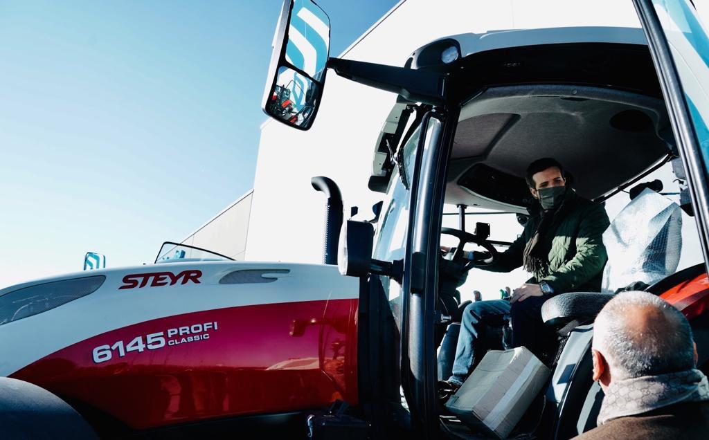 Pablo Casado, a bordo de un tractor en su visita a una fábrica en Palencia.