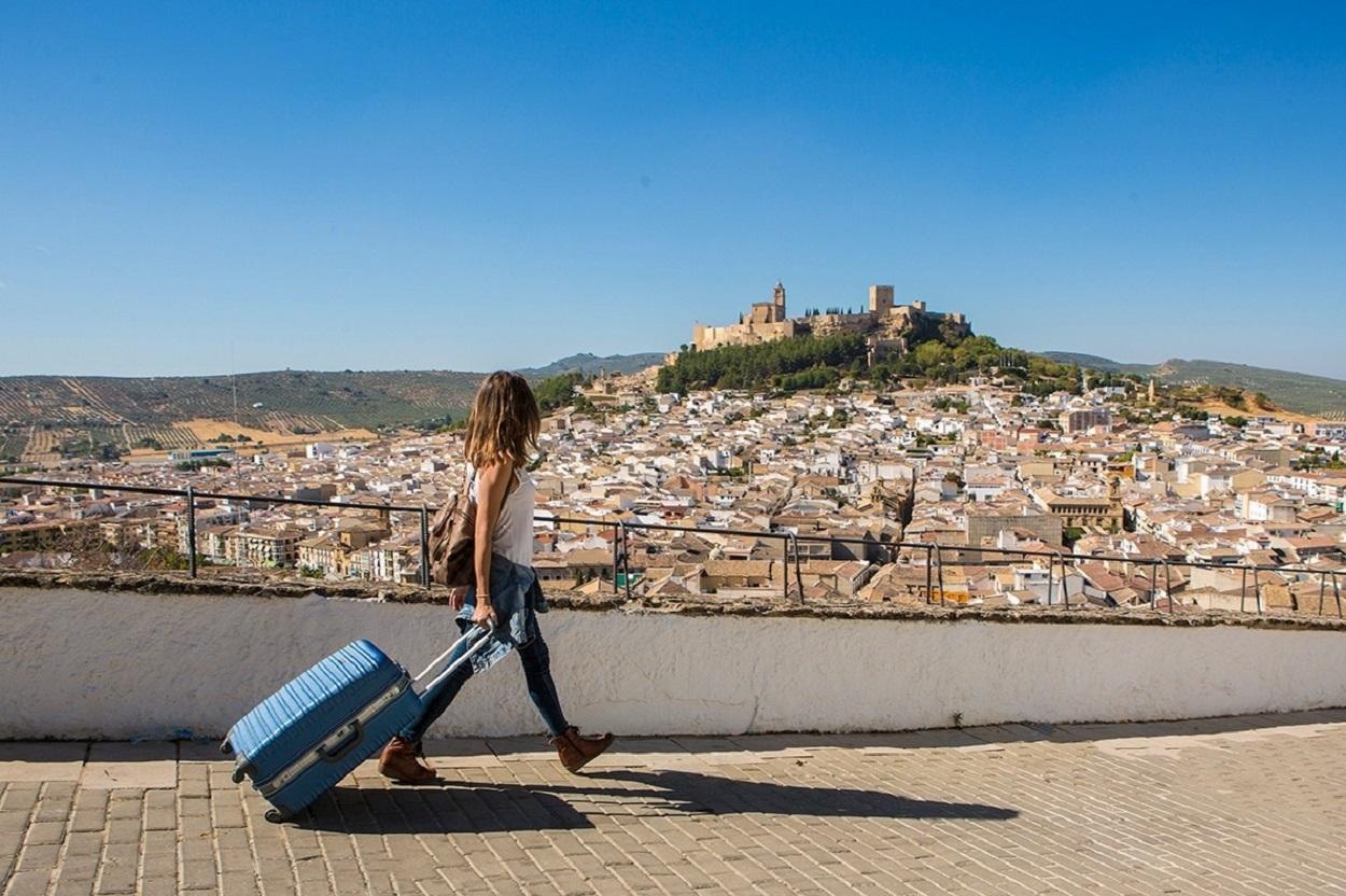 Una turista pasea por Alcalá la Real, con la Fortaleza de la Mota al fondo. Fuente: Europa Press.