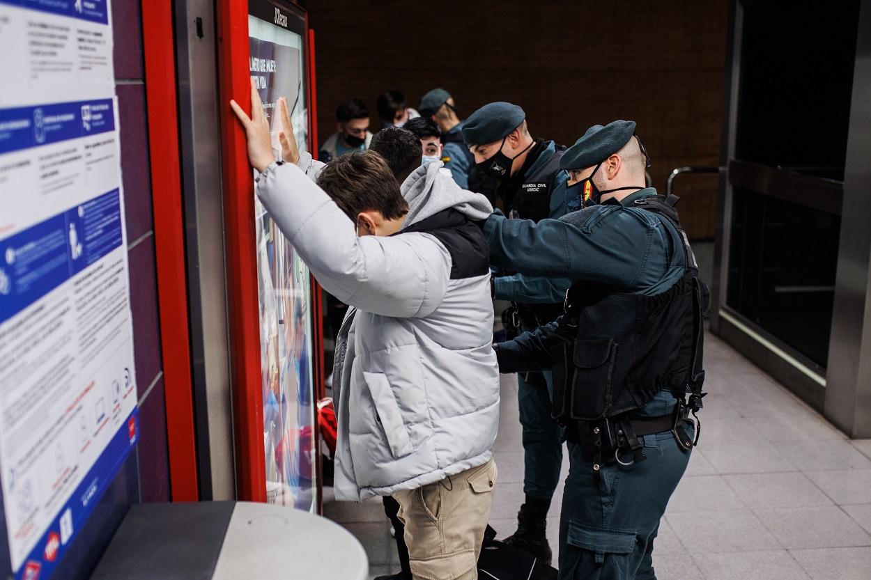 Agentes de la Guardia Civil cachean a jóvenes en un control para prevenir la violencia entre bandas juveniles, en la estación de metro de Arganda del Rey. Fuente: Europa Press.