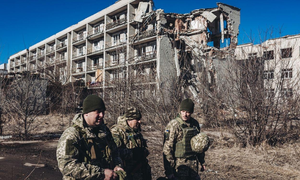 Varios soldados ucranianos caminan frente a un edificio derruido en un pueblo cercano a la línea de contacto, en Marinka, Oblast de Donetsk (Ucrania)