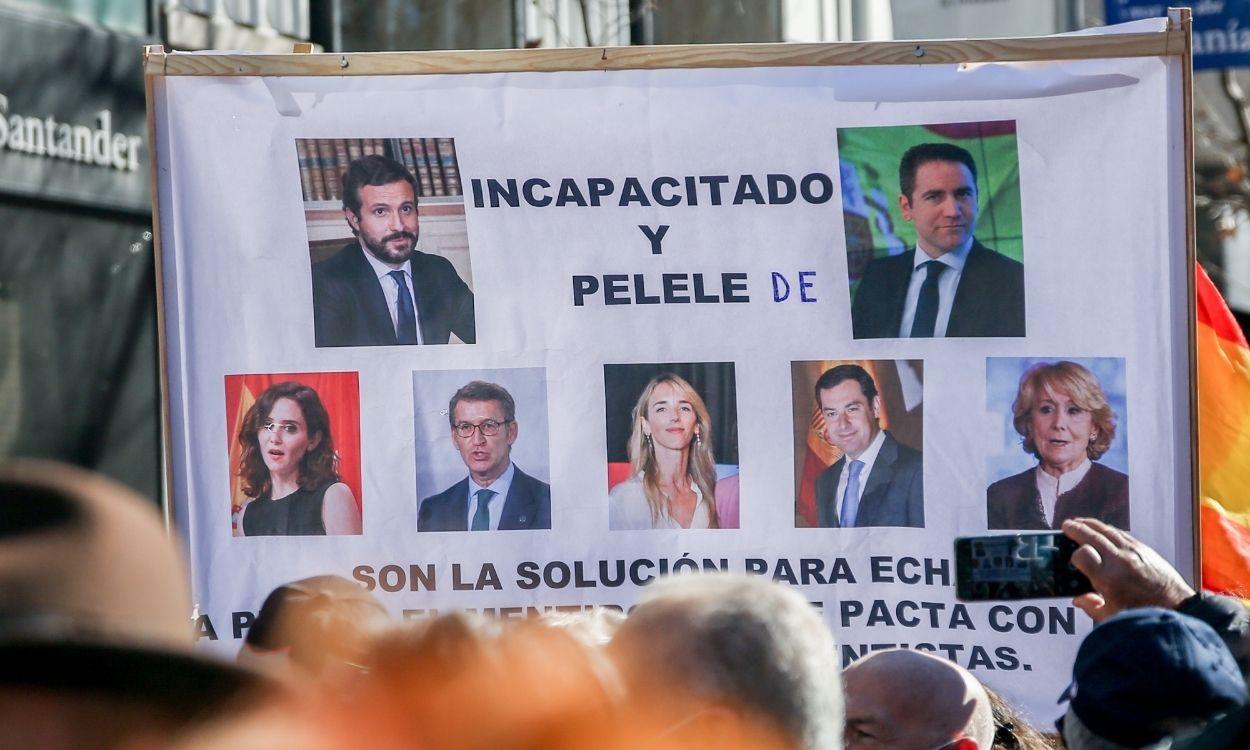 Varios manifestantes, con una pancarta que con imágenes de miembros del PP, en una concentración de apoyo a Díaz Ayuso, en la sede del Partido Popular, a 20 de febrero de 2022, en Madrid (España)