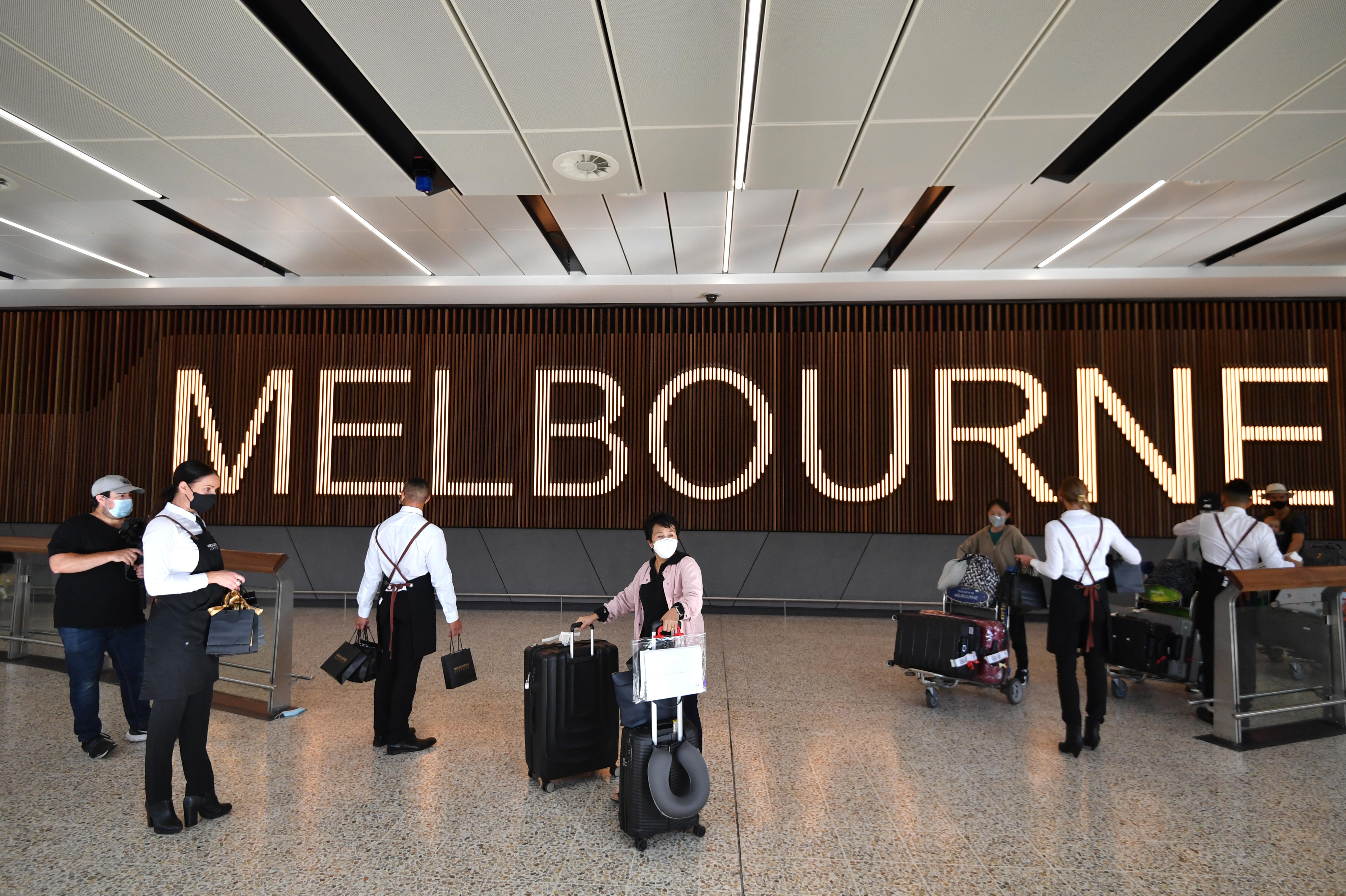 Varios viajeros llegan al aeropuerto internacional de Melbourne.