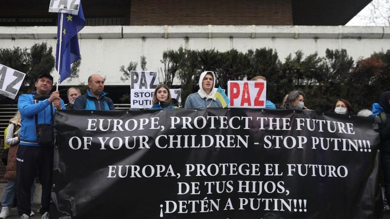 Varias personas con una pancarta participan en una nueva concentración ante la embajada rusa de Madrid tras los ataques en Ucrania.