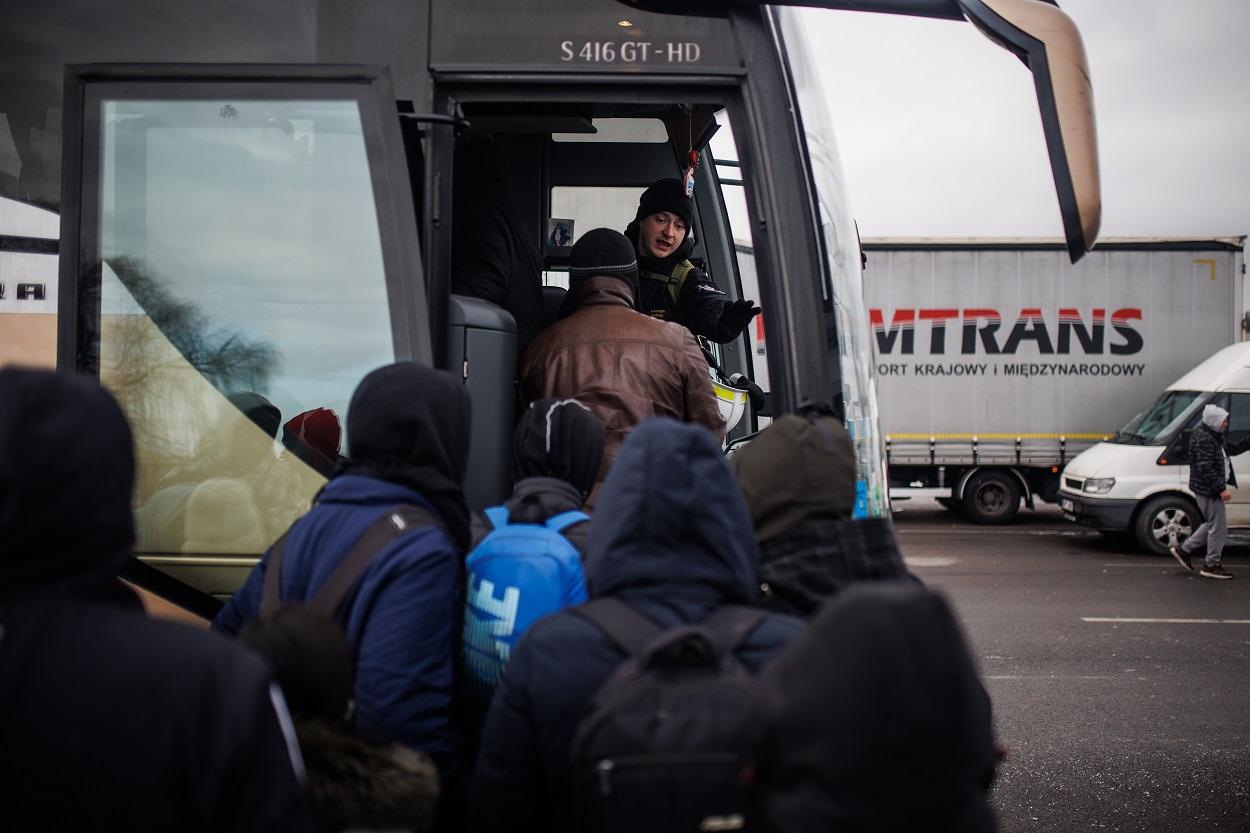 Varias personas suben a un autobús para salir de la zona fronteriza, en el paso fronterizo de Medyka (Polonia). Fuente: Europa Press.