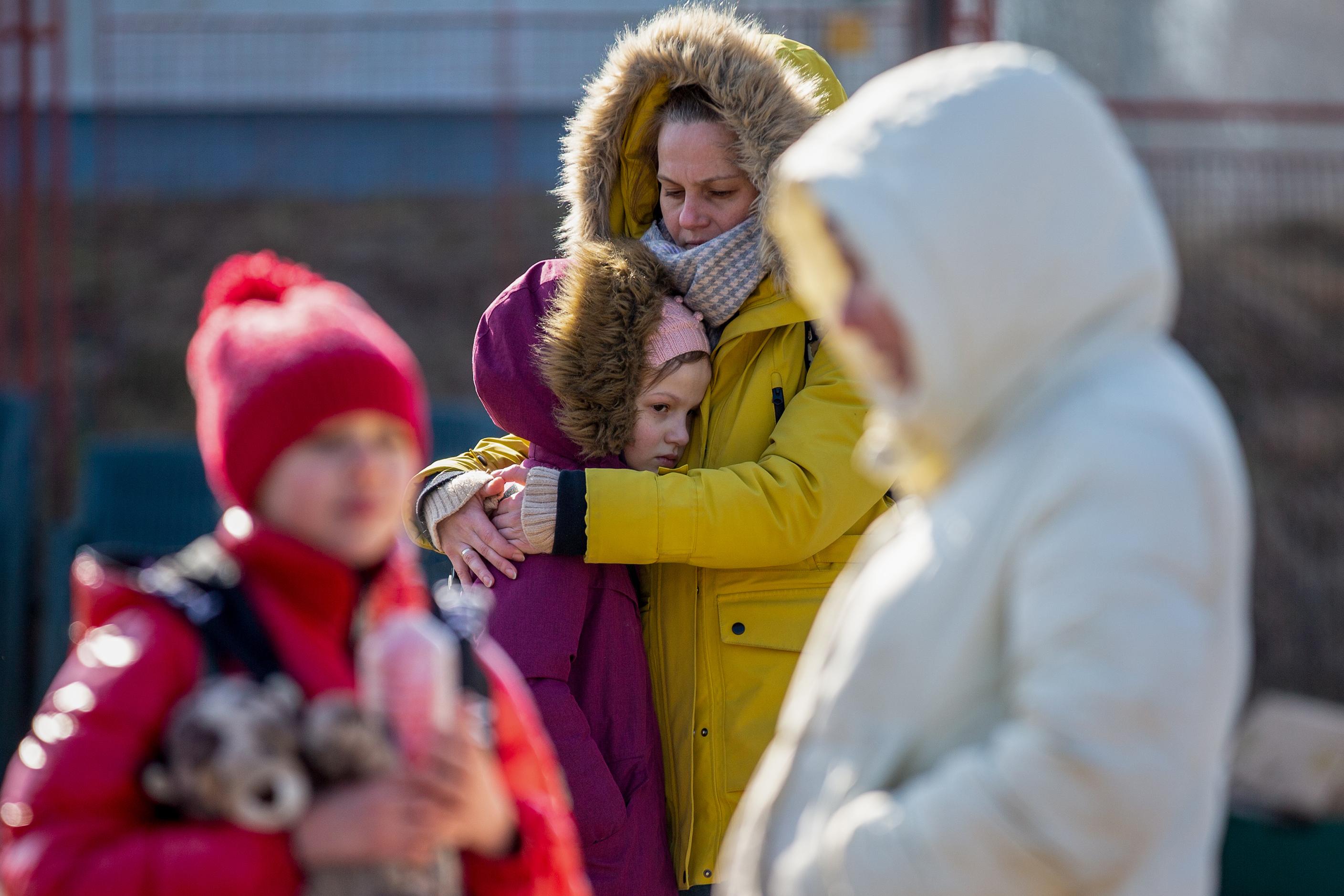 Una madre ucraniana abraza a su hija en la frontera polaca. EP.