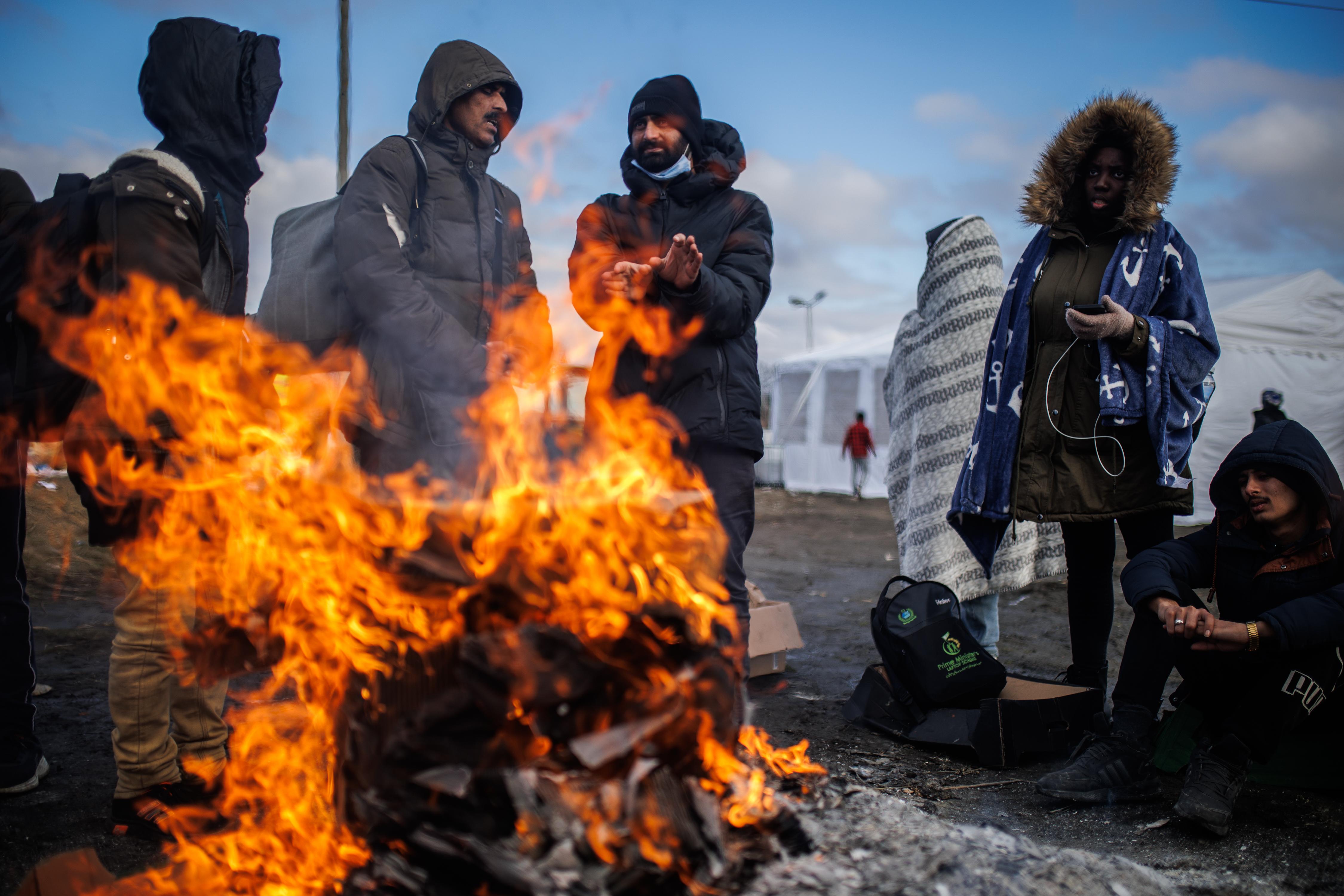 Varias personas se calientan con lumbre suben en el paso fronterizo de Medyka, a 28 de febrero de 2022, en Medyka (Polonia).