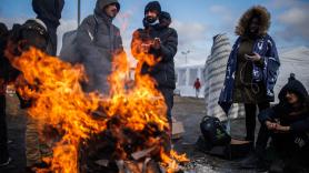 Varias personas se calientan con lumbre suben en el paso fronterizo de Medyka, a 28 de febrero de 2022, en Medyka (Polonia).