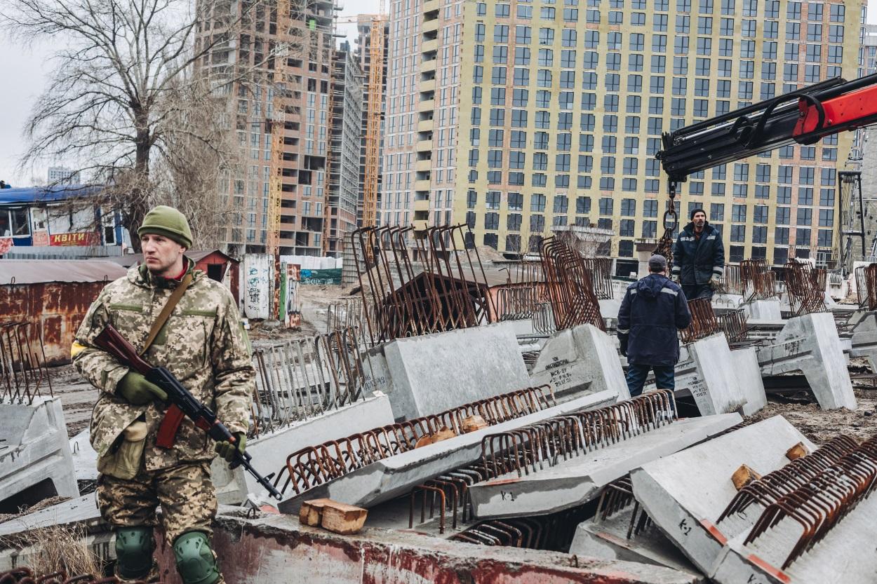 Dos operarios levantan losas de cemento para cortar carreteras, a 2 de marzo de 2022, en Kiev (Ucrania)