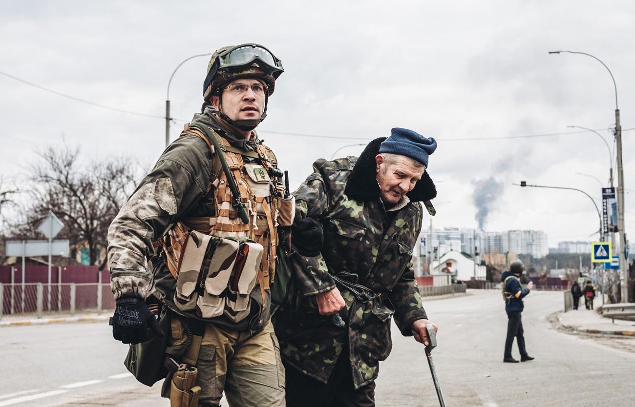 Un soldado ayuda a un anciano a escapar del bombardeo, a 6 de marzo de 2022, en Irpin
