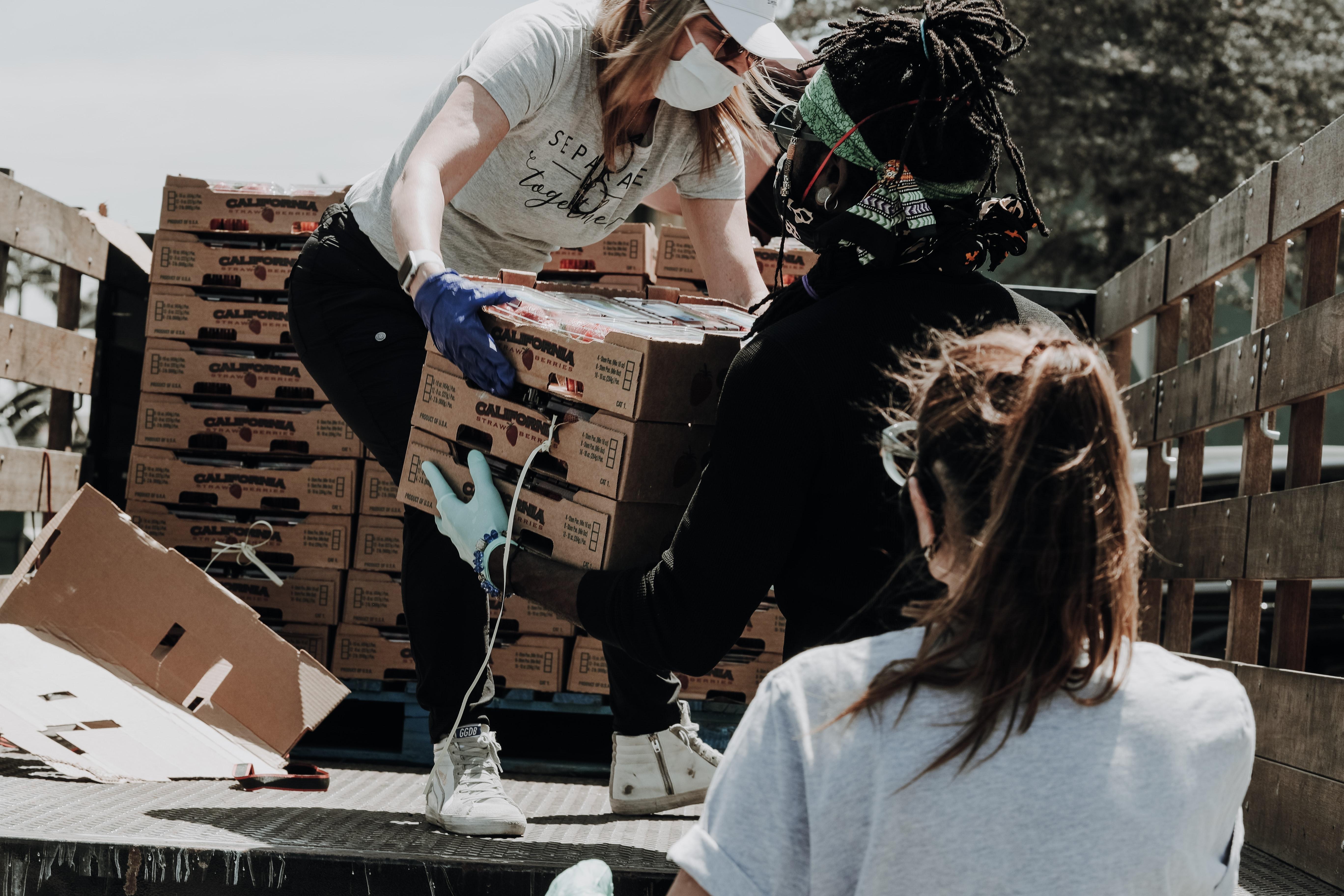 Personas cargando donaciones de comida