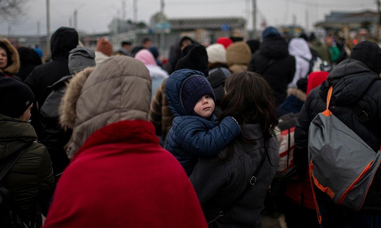 Varias personas y niños, esperan para cruzar a Rumanía, en el paso fronterizo de Porubne, a 5 de marzo de 2022, en el oeste de Ucrania.