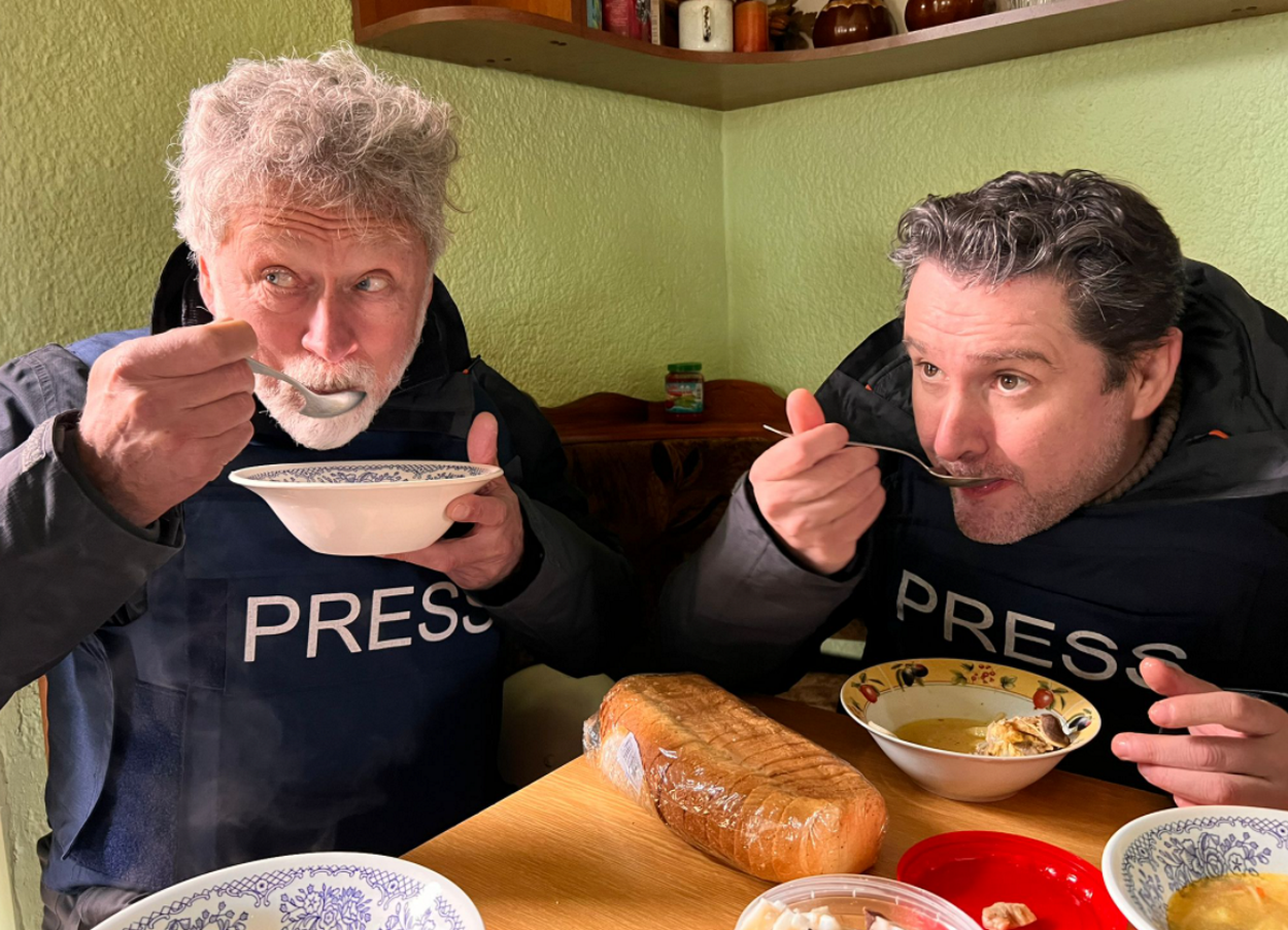 Oscar Mijallo junto a un compañero comiendo sopa en Ucrania