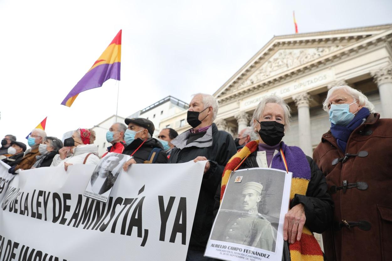 Varias personas sostienen una pancarta que reclama una Ley de Memoria que ponga fin a la impunidad del franquismo, frente al Congreso de los Diputados