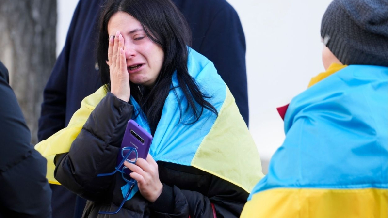 Joven ucraniana llora arropada con la bandera de su país. EP
