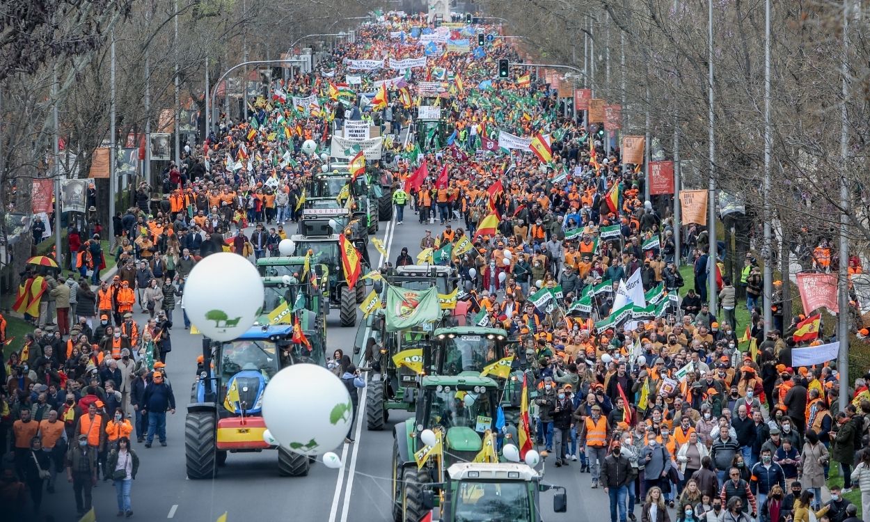 Varios tractores y manifestantes con pancartas, bandera, durante la marcha ‘20M’, a 20 de marzo de 2022, en Madrid (España). 