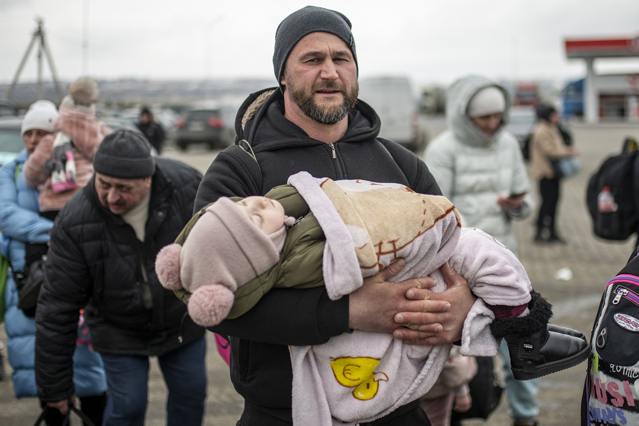 Un hombre con un niño en brazos en el paso fronterizo de Porubne, a 5 de marzo de 2022, en el oeste de Ucrania. EP