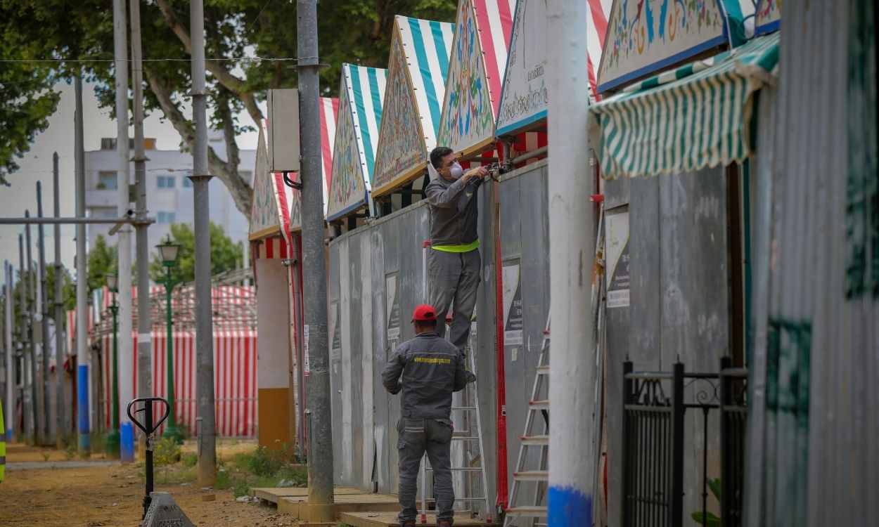 Dos operarios desmontan una caseta en las instalaciones de la Feria de Abril de Sevilla
