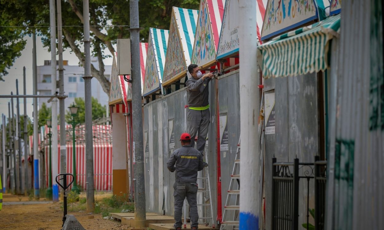 Dos operarios desmontan una caseta en las instalaciones de la Feria de Abril de Sevilla