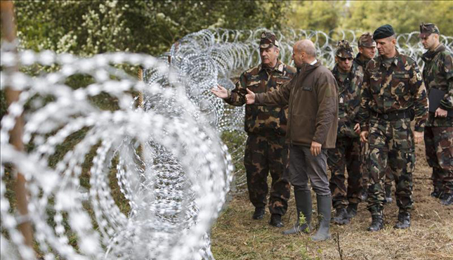El ministro de Defensa húngaro, Istvan Simicsko (2i) y el jefe de las Fuerzas húngaras, el coronel Tibor Benko (i) inspeccionan la valla fronteriza con Croacia en la localidad de Zakany, Hungría