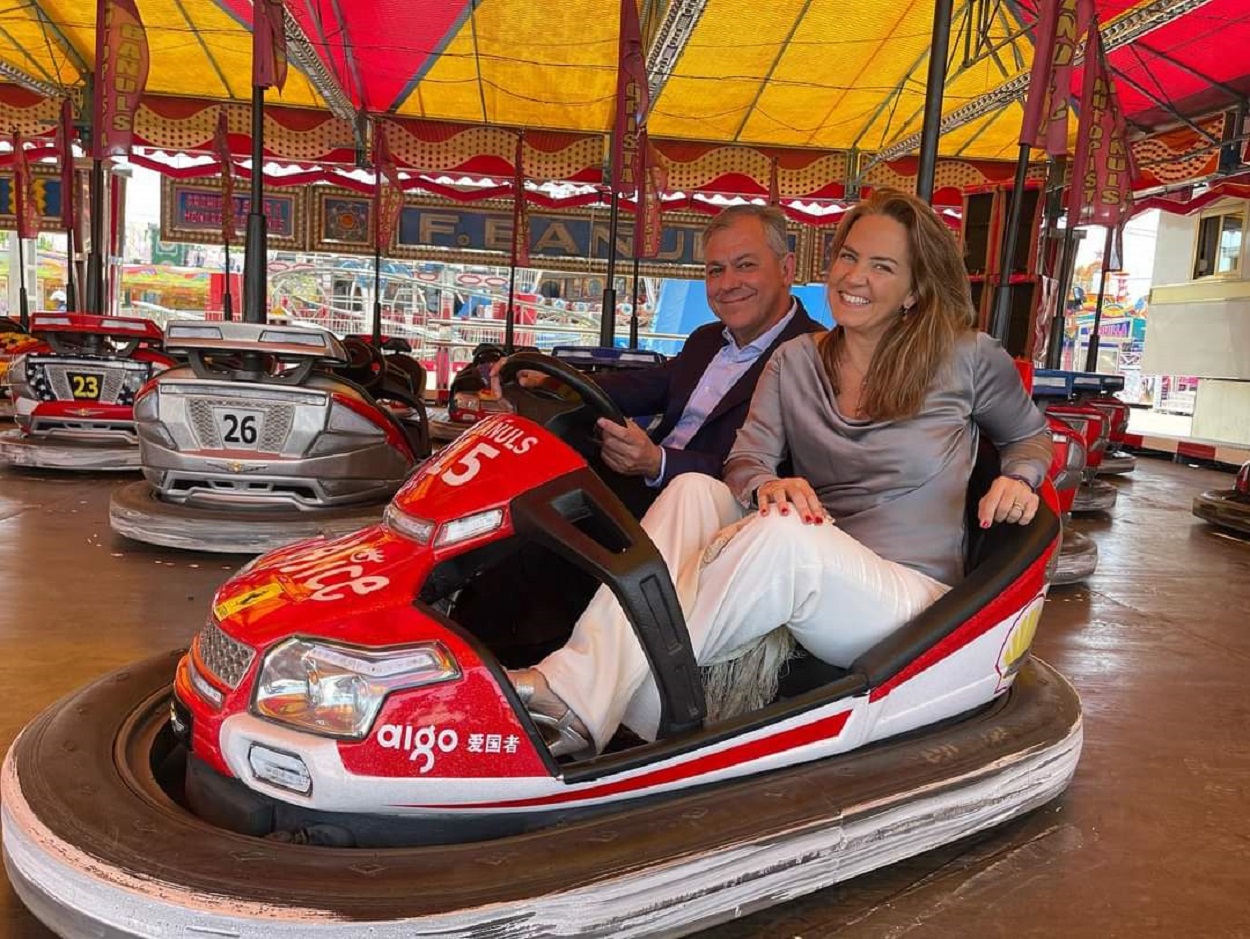 José Luis Sanz y Sol Cruz posan en una atracción de feria. EP.