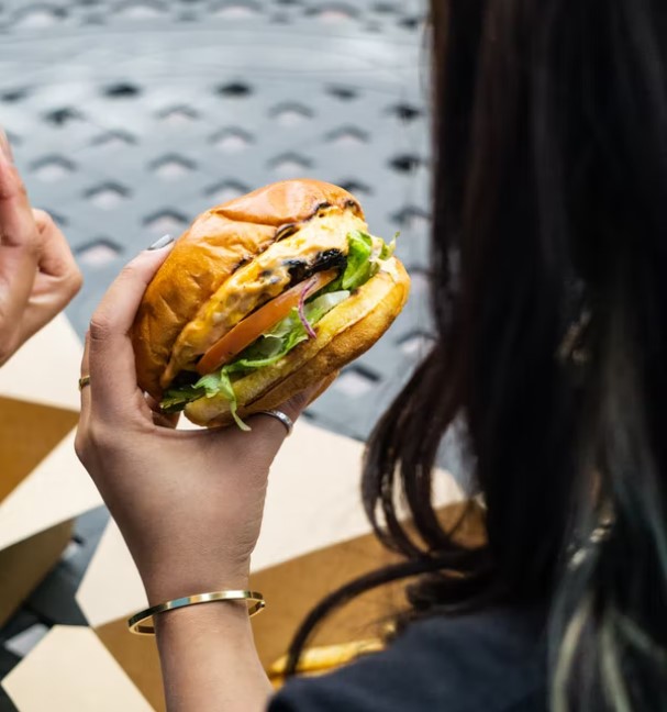 Mujer comiendo una hamburguesa