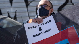 Un hombre con un cartel en el que se lee 'Uber más Ayuso es igual a Mandanga', durante una protesta anterior. Europa Press