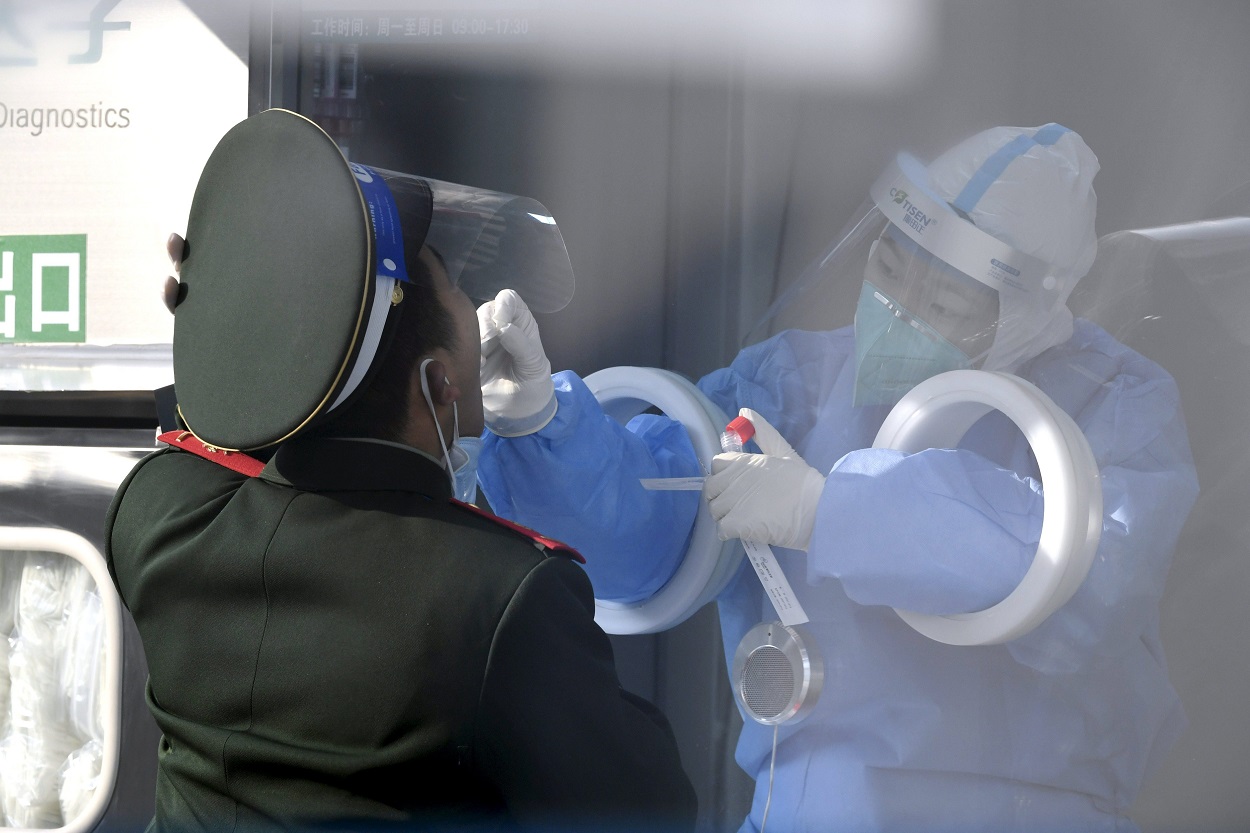 Imagen de recurso de una trabajadora sanitaria tomando la temperatura a un soldado en Pekin. Fuente: Europa Press.