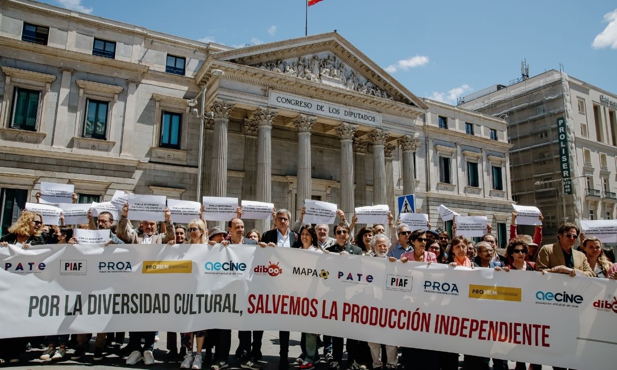 Manifestantes sujetan una pancarta en la que se lee 'Por la diversidad cultural, salvemos la producción independiente'. EP