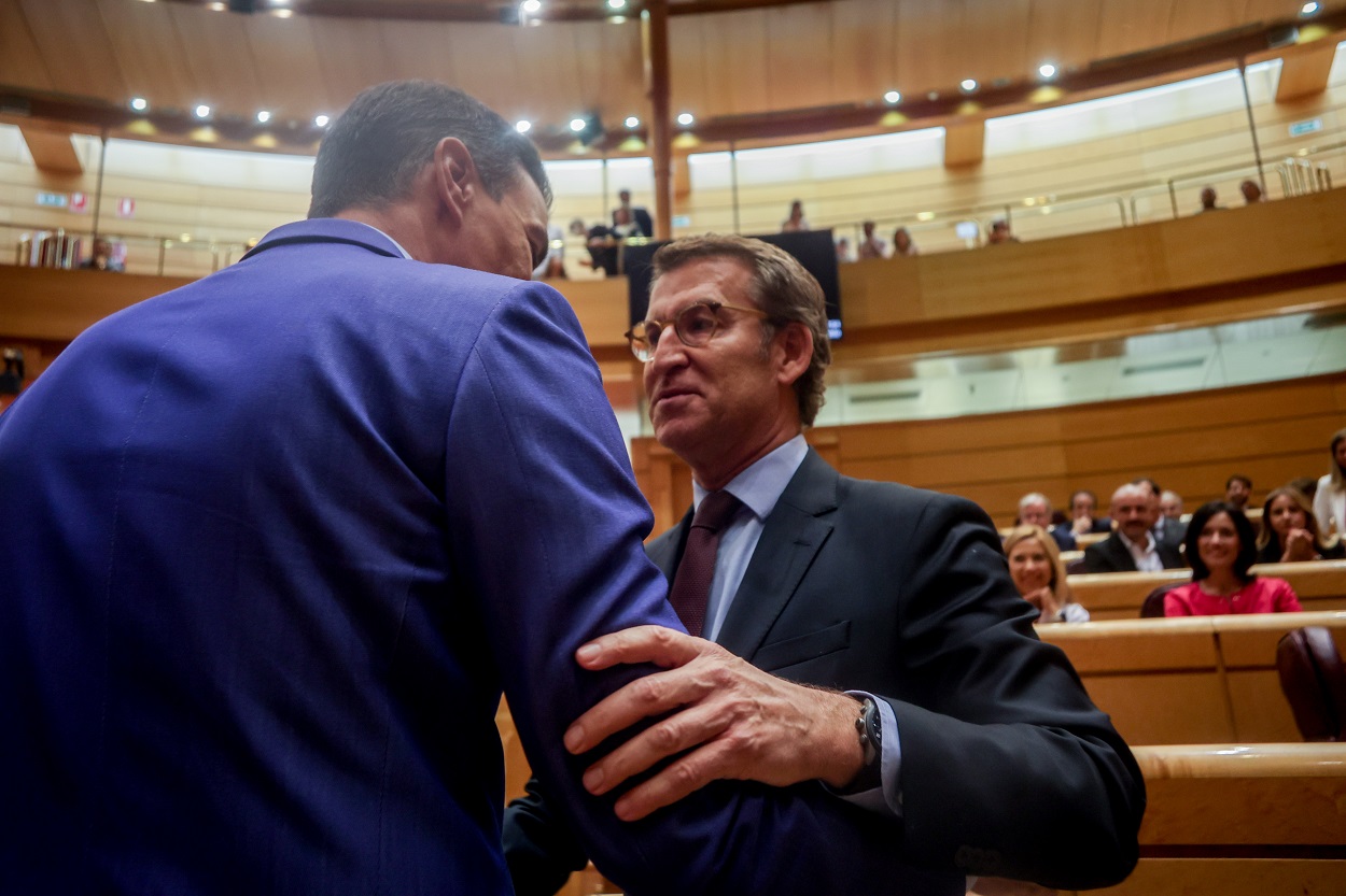 El presidente del Gobierno, Pedro Sánchez (i), y el líder del PP, Alberto Núñez Feijóo (d), se saludan en una sesión plenaria en el Senado. Fuente: Europa Press.