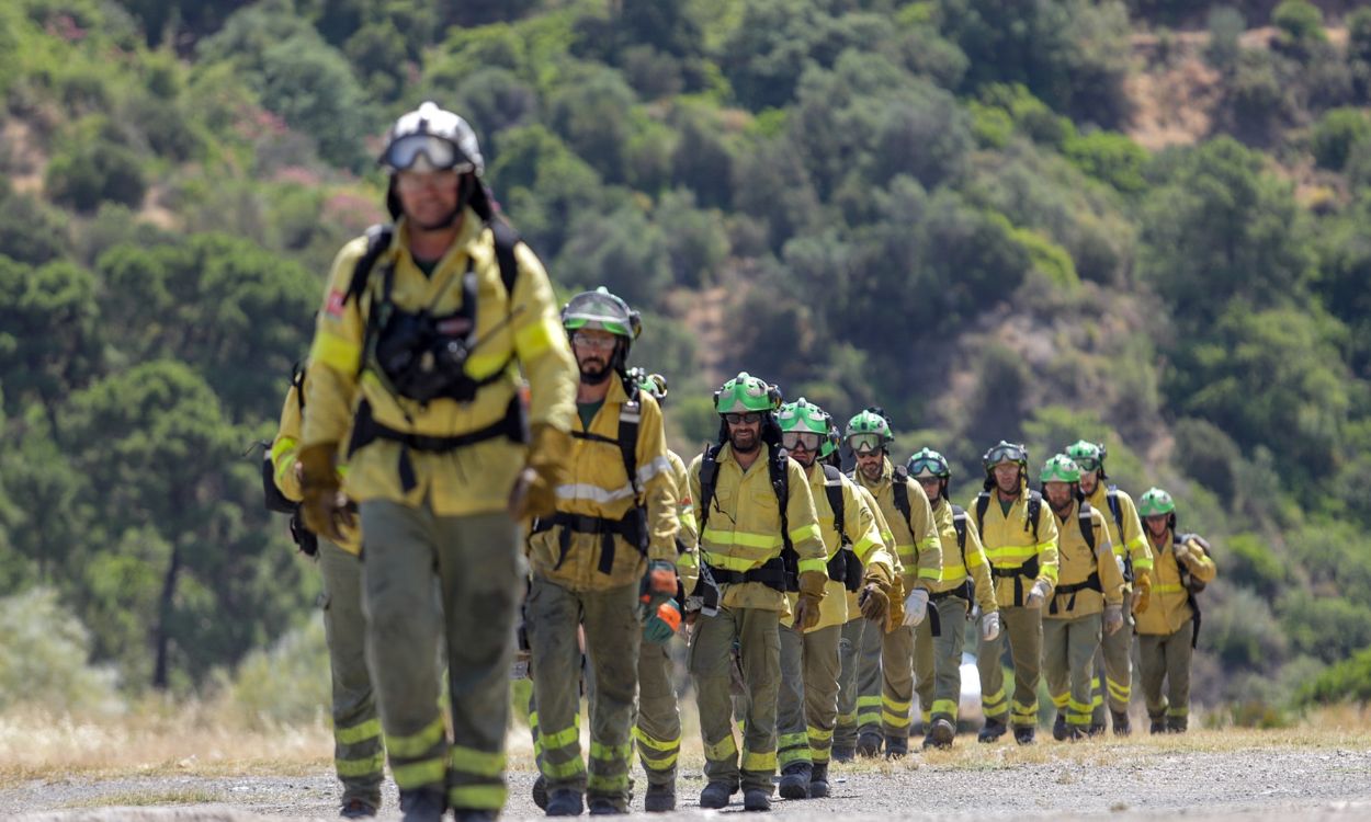 Bomberos que han estado trabajando toda la noche en el incendio forestal del Pujerra, llegan en helicóptero al puesto de mando. Europa Press.