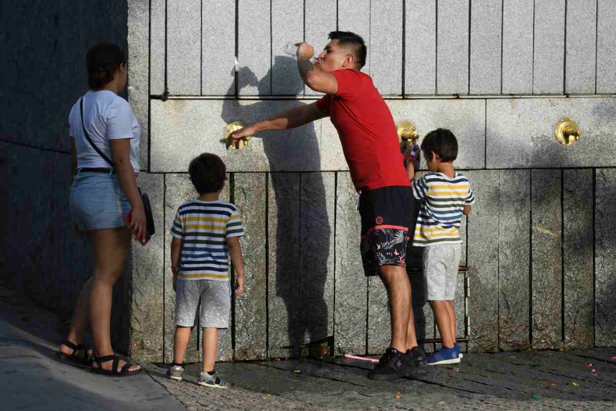 Imagen de archivo de varias personas bebiendo agua de uan fuente